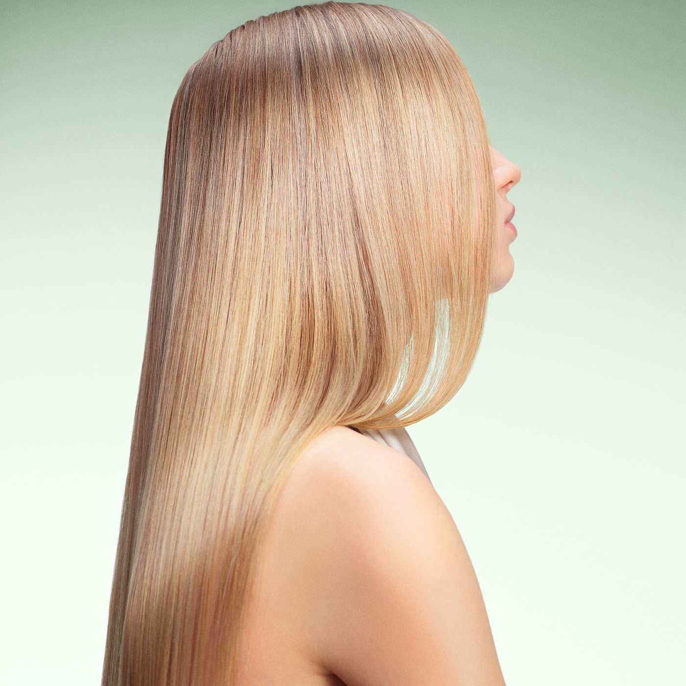Model with long, straight glossy blonde hair on green background.